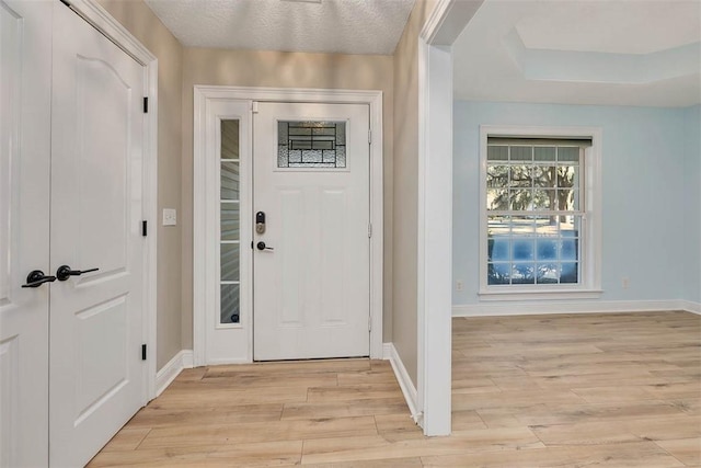 foyer entrance with light wood finished floors and baseboards