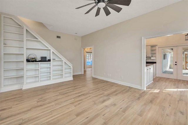 unfurnished living room with light wood finished floors, plenty of natural light, baseboards, and french doors