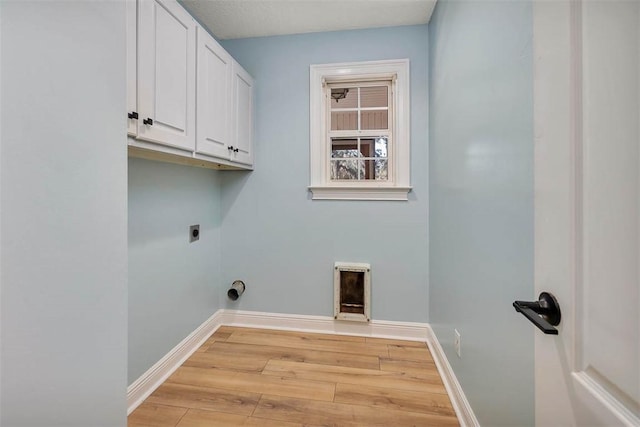 laundry room featuring hookup for an electric dryer, cabinet space, light wood-style flooring, and baseboards