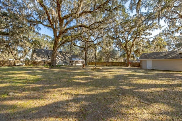 view of yard with a fenced backyard, an outdoor structure, and a shed