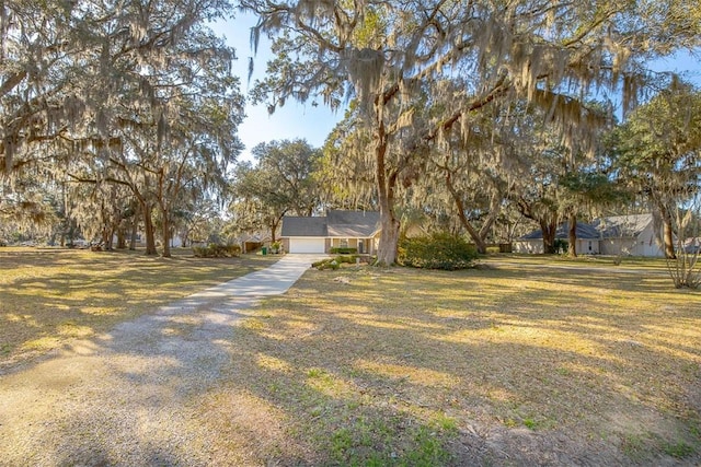 view of front facade featuring a garage, a front yard, and driveway