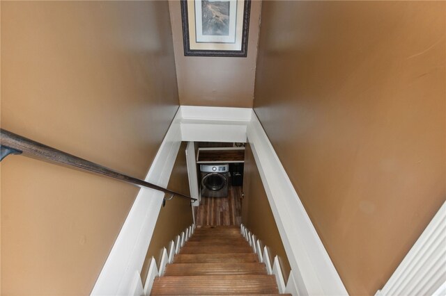 stairway with hardwood / wood-style flooring and washer / clothes dryer