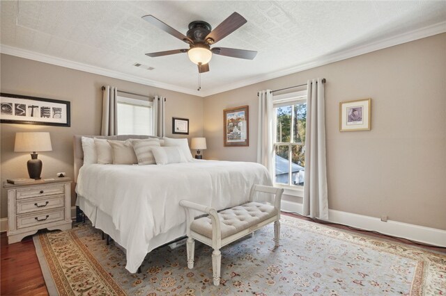 bedroom with a textured ceiling, ceiling fan, dark hardwood / wood-style flooring, and crown molding