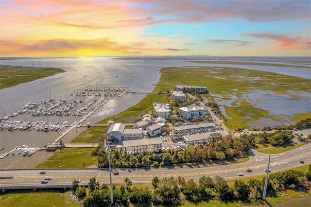 aerial view at dusk featuring a water view