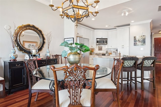 dining space with dark hardwood / wood-style floors, ornamental molding, and a chandelier