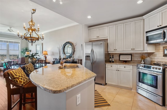 kitchen featuring stainless steel appliances, white cabinetry, and a center island with sink