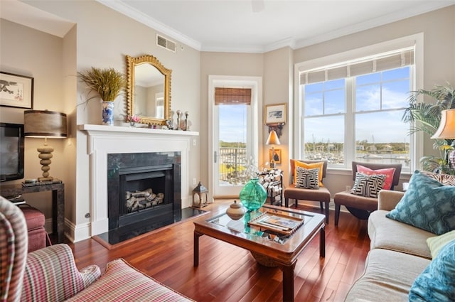 living room featuring dark hardwood / wood-style flooring, crown molding, and a healthy amount of sunlight