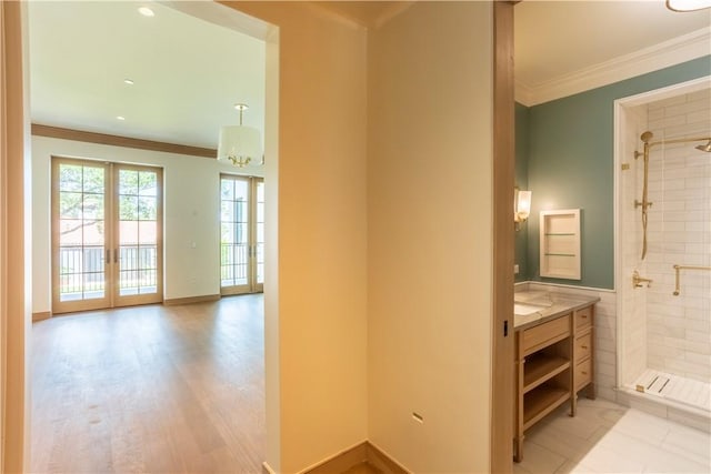 hall featuring light hardwood / wood-style floors, ornamental molding, and french doors