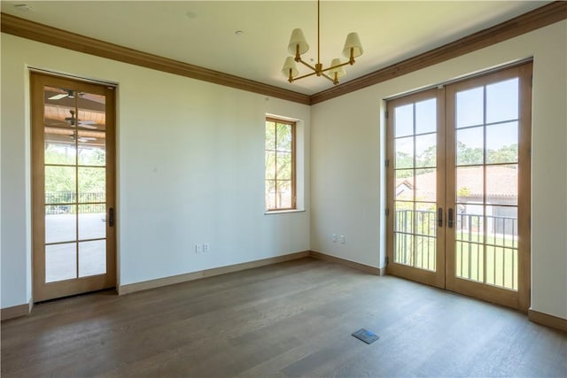 empty room with hardwood / wood-style flooring, ornamental molding, and french doors