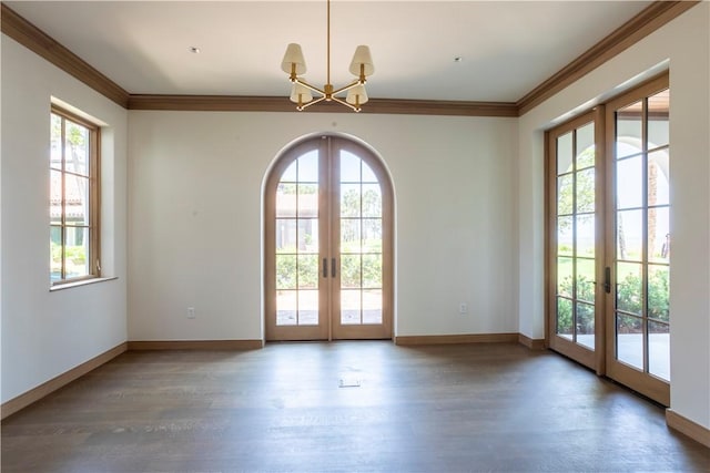 entryway with dark wood-type flooring, ornamental molding, and french doors