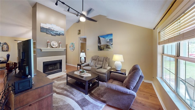 living room with hardwood / wood-style floors, ceiling fan, a wealth of natural light, and vaulted ceiling