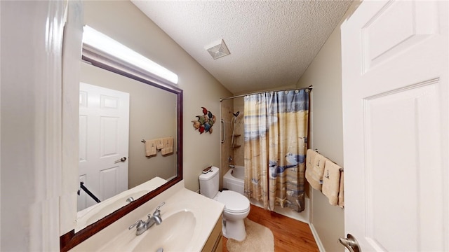 full bathroom with vanity, shower / bath combination with curtain, toilet, a textured ceiling, and wood-type flooring