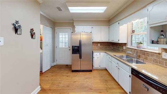 kitchen featuring sink, light hardwood / wood-style flooring, appliances with stainless steel finishes, white cabinets, and ornamental molding