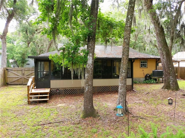 back of house featuring central air condition unit and a sunroom