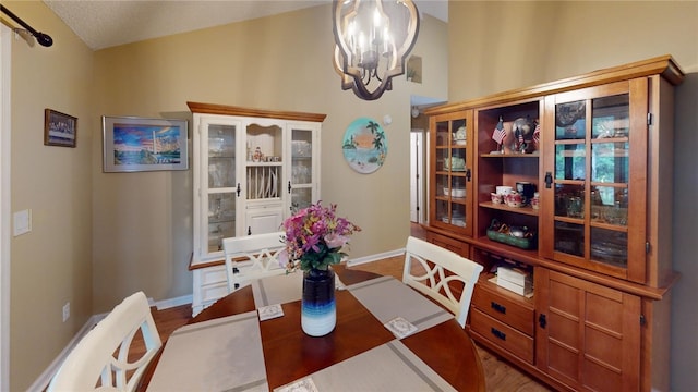 dining space with hardwood / wood-style floors, a textured ceiling, and a notable chandelier