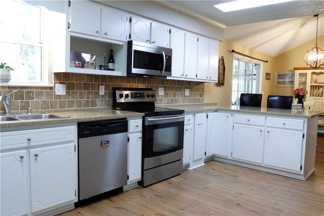 kitchen with kitchen peninsula, a healthy amount of sunlight, white cabinets, and stainless steel appliances