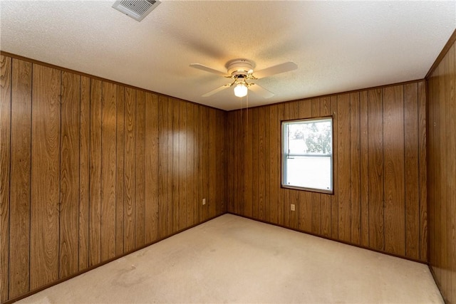 2320 Ben Hill Ave, Waycross, GA 31501 - empty room featuring light colored carpet, a ceiling fan, wooden walls, and a textured ceiling