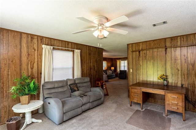 2320 Ben Hill Ave, Waycross, GA 31501 - living area with wood walls, light carpet, and a ceiling fan