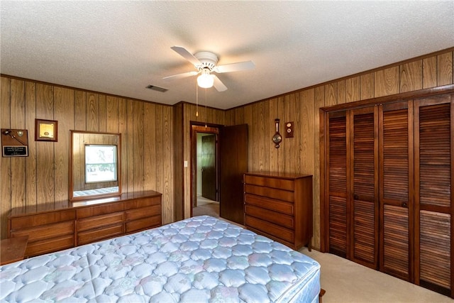 2320 Ben Hill Ave, Waycross, GA 31501 - carpeted bedroom with wooden walls, a closet, ornamental molding, ceiling fan, and a textured ceiling