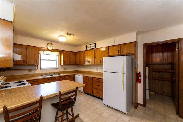 2320 Ben Hill Ave, Waycross, GA 31501 - kitchen with white appliances, brown cabinets, light flooring, ventilation hood, and a peninsula