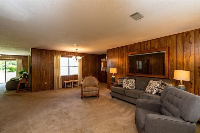 2320 Ben Hill Ave, Waycross, GA 31501 - carpeted living room featuring healthy amount of natural light, wood walls, a chandelier, and a textured ceiling