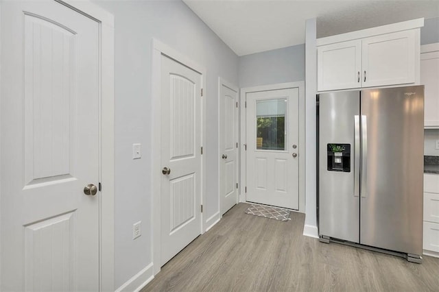 interior space featuring baseboards and light wood finished floors