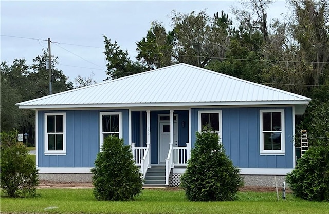 view of front of property with board and batten siding, a porch, and metal roof