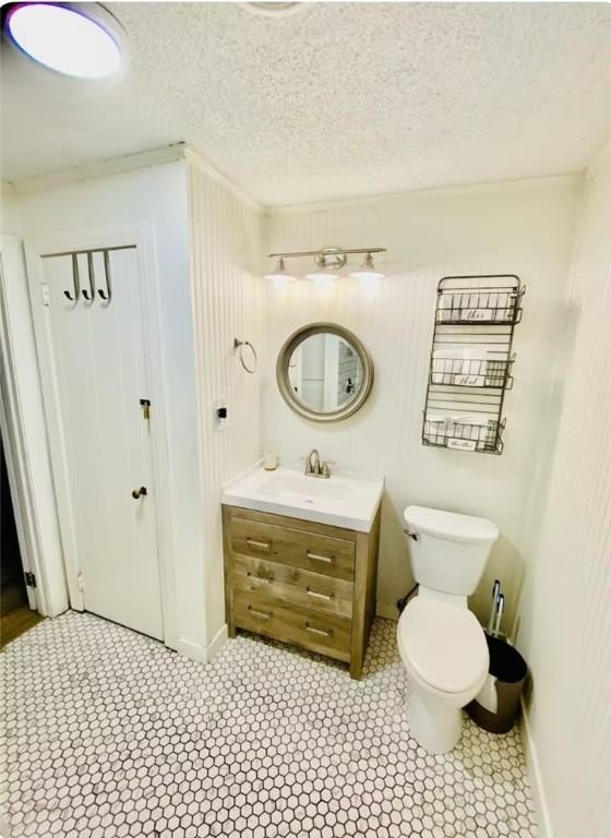 bathroom with vanity, toilet, and a textured ceiling