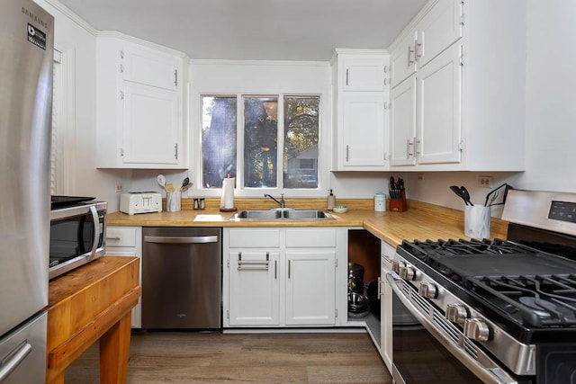 kitchen with white cabinets, dark hardwood / wood-style flooring, stainless steel appliances, and sink