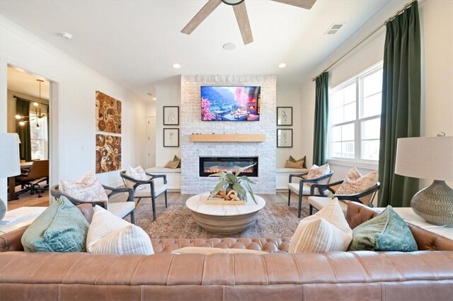 living area featuring a fireplace, visible vents, and wood finished floors