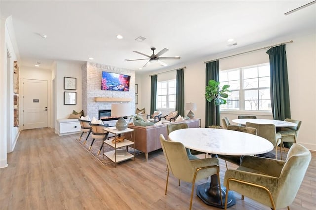 living area featuring ceiling fan, recessed lighting, a fireplace, and light wood-style floors