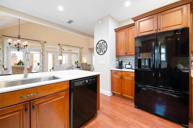 kitchen with brown cabinetry, visible vents, and black appliances