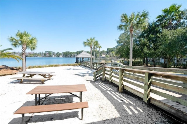 view of property's community with a water view, fence, and a gazebo