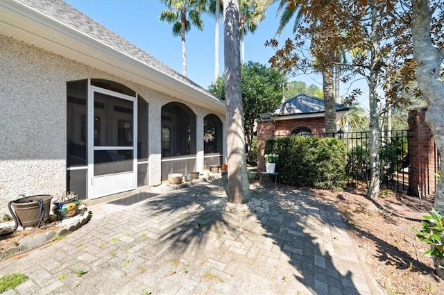 view of patio featuring a sunroom and fence