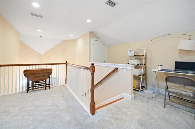 office area with carpet, visible vents, and vaulted ceiling