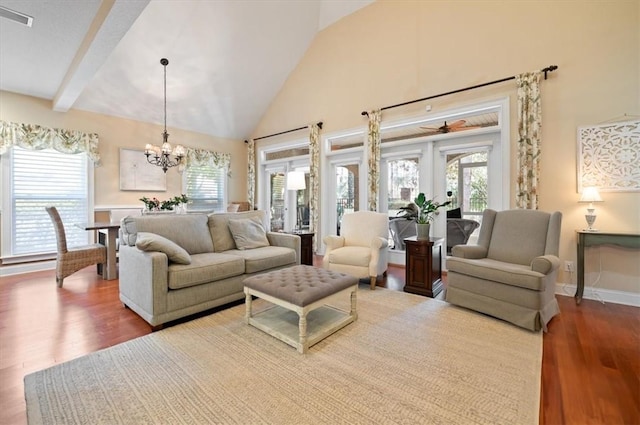 living area with a chandelier, high vaulted ceiling, wood finished floors, visible vents, and beam ceiling