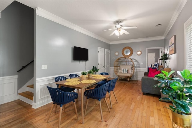 dining space with light wood-type flooring, ceiling fan, and crown molding