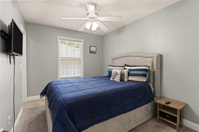 carpeted bedroom with a textured ceiling and ceiling fan