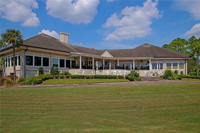 rear view of house featuring a yard