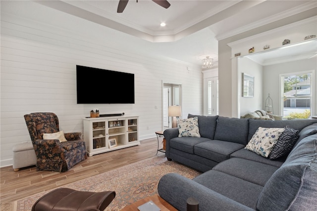 living room featuring hardwood / wood-style floors, ceiling fan, and crown molding