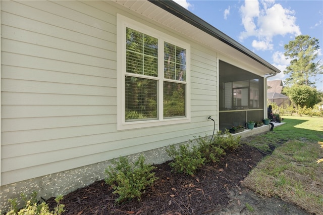 view of home's exterior with a lawn and a sunroom