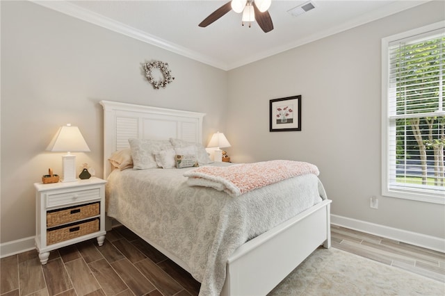 bedroom with hardwood / wood-style floors, ceiling fan, ornamental molding, and multiple windows