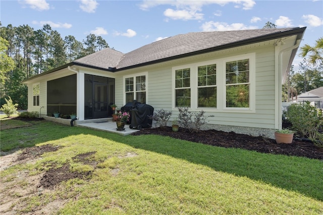 rear view of house with a yard and a sunroom