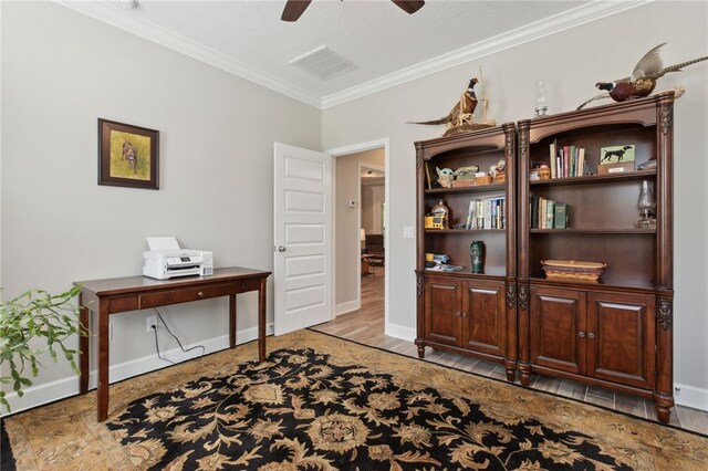 office space with crown molding, ceiling fan, a textured ceiling, and light wood-type flooring