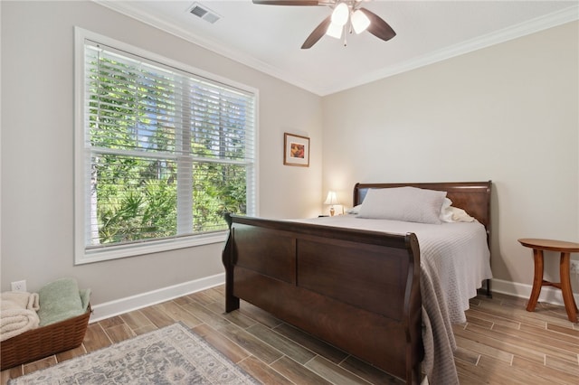 bedroom with multiple windows, ceiling fan, hardwood / wood-style floors, and crown molding