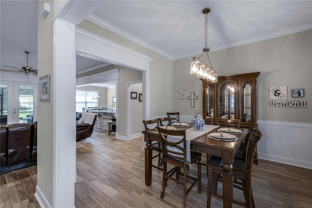 373 Harbour Island Cir, Waverly, GA 31565 - dining space with a ceiling fan, wood finished floors, french doors, ornamental molding, and a wainscoted wall