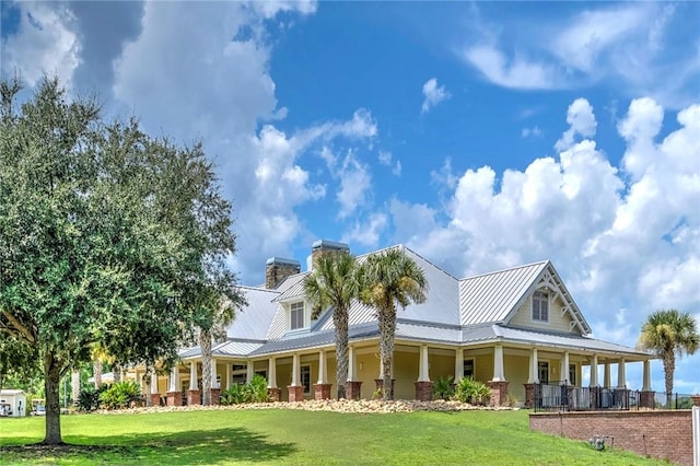 373 Harbour Island Cir, Waverly, GA 31565 - country-style home with covered porch, a front lawn, and a metal roof