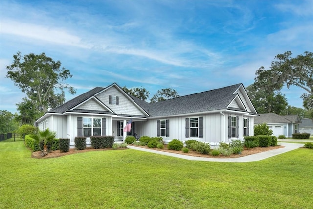 373 Harbour Island Cir, Waverly, GA 31565 - view of front of house with board and batten siding, a front lawn, and roof with shingles