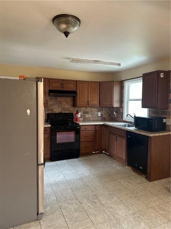 kitchen featuring sink, backsplash, and black appliances