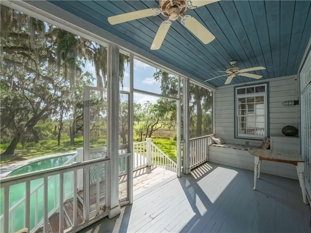 unfurnished sunroom with a ceiling fan